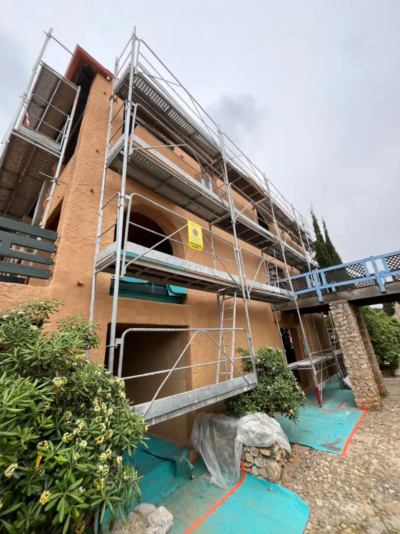 Façade d'un bâtiment collectif recouverte d'échafaudages pendant des travaux