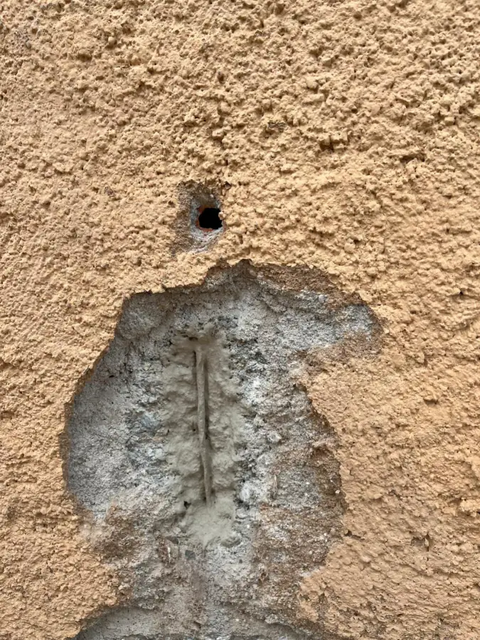 Reprise au mortier d'une fissure ouverte dans un enduit de façade