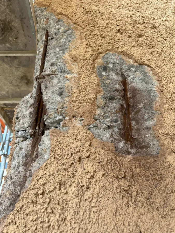 Armatures métalliques corrodées mises à nu dans un poteau béton de façade avant traitement