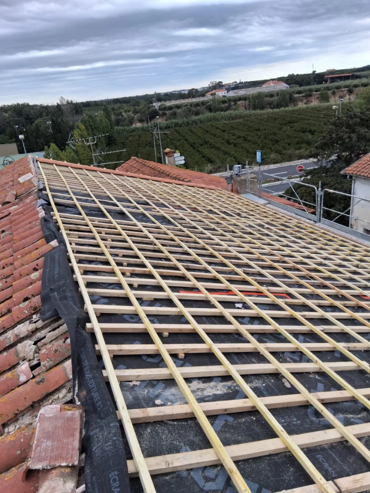 Préparation d'une toiture en tuiles pendant un chantier de couverture à Trouillas